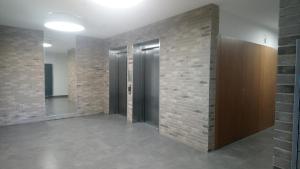 einen Flur mit Türen und Ziegelwand in der Unterkunft Apartament Wiatraczna in Warschau + 2 Fotos