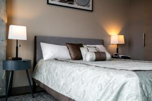 a bedroom with a large bed with two lamps at Sable 803 - Alcove in Minneapolis