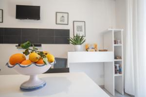 a bowl of oranges on a table in a kitchen at Catania Over Time - Tourist Rooms in Catania