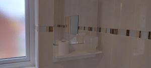 a bathroom with a toilet paper dispenser and a mirror at Entire 2 bedroom home with parking in Coventry, UK in Coventry +53 photos