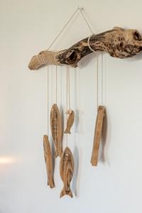 a group of wooden utensils hanging on a wall at Sardine argentée Plage à 100m Surf Randos GR 223 Jardin in Surtainville