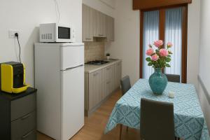 a kitchen with a table and a white refrigerator at SOGNO D'ESTATE 2 in Mazara del Vallo