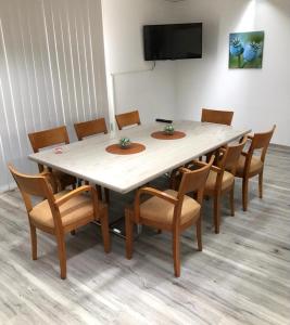 a large table with chairs and a television in a room at Hostel Apartment in Castrop-Rauxel
