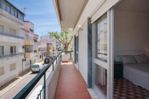 a balcony of a building with a bedroom and a bed at Apartamento Gaspar in Vila Real de Santo António