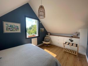 a bedroom with a blue wall and a window at Ty Glazu Doelan espace 60m2, Port& criques à pied, 2 chambres privées au 1er étage, SDB, WC séparé in Clohars-Carnoët