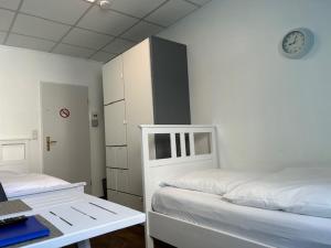 a room with two beds and a clock on the wall at Hostel Apartment in Castrop-Rauxel
