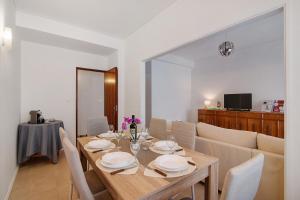 a dining room with a wooden table and chairs at Apartamento Gaspar in Vila Real de Santo António