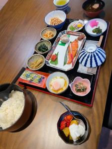 a table topped with plates of food and bowls of rice at Hot Spring Inn Hyoutan in Kusatsu