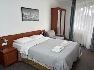 a bedroom with a large bed and a chair at АВІА in Uzhhorod