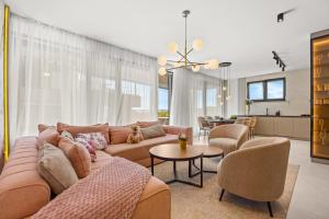 ザダルにあるLuxury Pool Seaside Apartments Zadarのソファと椅子、キッチンのあるリビングルーム
