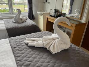 a bedroom with two swans towels on a bed at The Ashleigh in Paignton