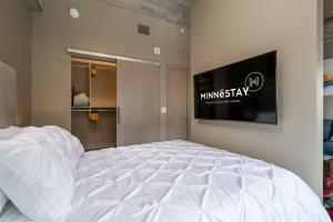 a large white bed in a room with a television at Sable 404 - Alcove in Minneapolis +26 photos