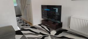 a living room with a television on a wall at Entire 2 bedroom home with parking in Coventry, UK in Coventry