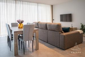 a living room with a couch and a table with chairs at Villa Nicuma by ESCAPE to Madeira in Calheta