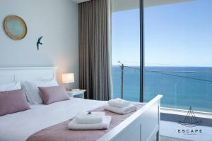 a bedroom with a bed with a large window at Villa Nicuma by ESCAPE to Madeira in Calheta +25 photos