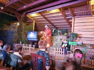un grupo de niños observando a una mujer en un escenario en Camping Le Barutel, en Meyras