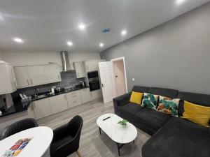a living room with a couch and a table at Ilford, Luxury Flat 3 close to station in Ilford