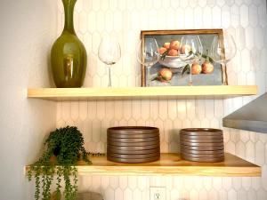 a shelf with plates and wine glasses and a vase at Huge Home near Old Folsom Pet & Family Friendly in Folsom