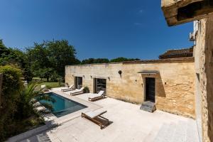 una piscina al aire libre con tumbonas junto a un edificio en La Girondine - Piscine, billard, vigne et estuaire, en Gauriac