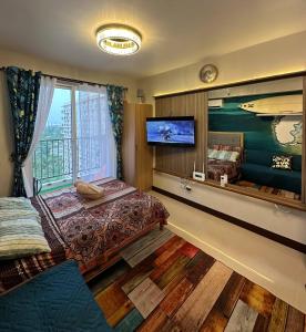 ein Schlafzimmer mit einem Bett und einem Flachbildfernseher in der Unterkunft Sun Drift Studio near airport with Pool and Parking in Lapu Lapu City