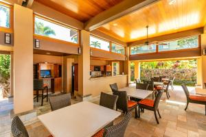 a dining room with tables and chairs and windows at Wailea Elua 2305 by Coldwell Banker Island Vacations in Wailea