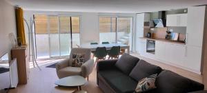 a living room with a couch and a kitchen at Appartement, en bord du GR34 in Hillion