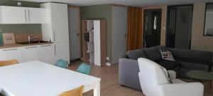 a living room with a couch and a table and chairs at Appartement, en bord du GR34 in Hillion
