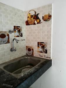 a kitchen with a sink with pictures on the wall at Nandankanan Motel in Bārang +4 photos