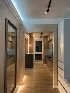 a hallway leading to a kitchen with a mirror at RIN SkyLounge Apartment in Cluj-Napoca +18 photos