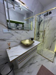 a bathroom with a sink and a glass shower at RIN SkyLounge Apartment in Cluj-Napoca +18 photos