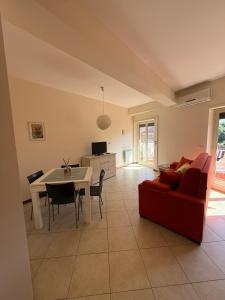 a living room with a red couch and a table at Heliomar Naxos - Your Balcony on the Sea in Giardini Naxos +20 photos