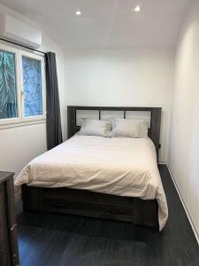 a bedroom with a large bed with white sheets and a window at Le Moulin des Sens - Grasse in Grasse
