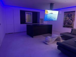 a purple living room with a couch and a tv at Le Moulin des Sens - Grasse in Grasse