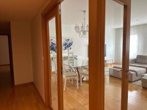 a dining room and living room with a glass table at Azores Lava Apartment T3 in Ponta Delgada