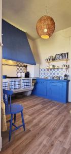 a kitchen with blue cabinets and a blue table at Alma House - Caminha in Caminha