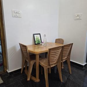 a wooden table with chairs in a room at Padmini's home stay New apartment 2bhk in Tirupati +8 photos