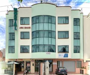 an apartment building with a car parked in front of it at Hostal Abu Dhabi in Cuenca