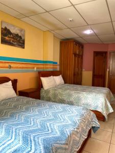 a hotel room with two beds in a room at Hostal Abu Dhabi in Cuenca