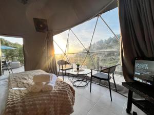 a bedroom with a bed and a large window at Nomaddome Glamping Hotel in Mishmish