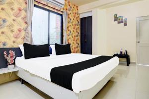 ナーグプルにあるSuper Hotel O Sunshine Palaceの大きな窓のある部屋にある大きなベッド +21枚の写真