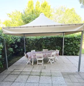 ein weißes Zelt mit einem Tisch und Stühlen darunter in der Unterkunft Dimora Scacciapensieri a Marina di Cecina by Zoom In Earth in Marina di Cecina