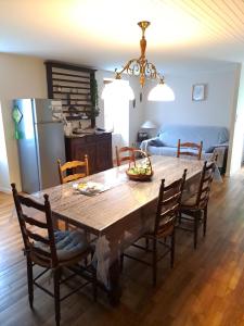 a kitchen and dining room with a wooden table and chairs at Le Moulin d'Hélène in Meymac