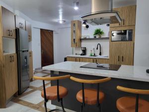 a kitchen with wooden cabinets and a counter with stools at Mi Lido Chalet in El Morro de Barcelona