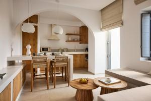 an open kitchen with wooden cabinets and a table at Dash Milos in Tripití