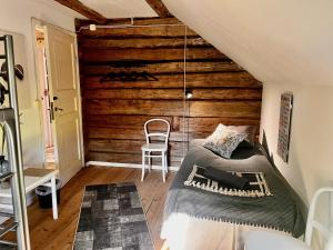 a room with a bed and a wooden wall at Rosengården - Viby B&Bi in Vretstorp