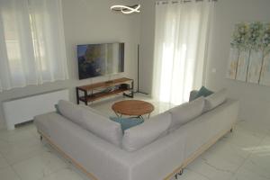a white living room with a couch and a table at Issos House in Agios Georgios