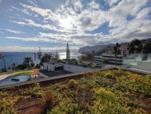 a house with a view of the ocean at Breathtaking Oceanfront Living, Sunset Facing 3-Bedroom Flat in Acqua Residences in Funchal