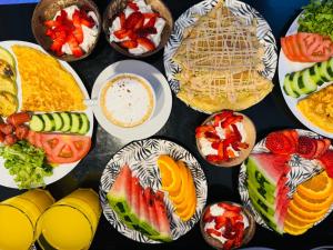 a table topped with plates of food and fruit at Villa White in Ksamil
