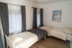 two beds in a small room with a window at Kuća na ušću in Olovo