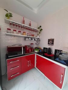 a kitchen with red cabinets and a red counter top at Casa para COP 30 in Belém
